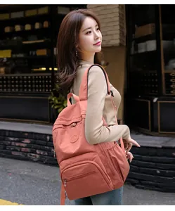 Détail du sac à dos en nylon rose corail avec tissu texturé et poche avant zippée