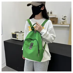Detail view of a bright green nylon backpack with front pocket and metal buckle clasp