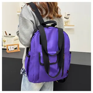 Detail of purple waterproof nylon backpack with black straps and front flap pocket