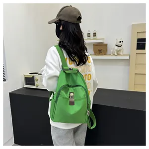 Detail of green nylon backpack with metal buckle and functional front zipper pocket