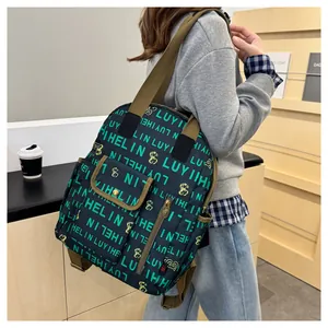 Detail showing the green letter print and yellow cartoon design on a black backpack