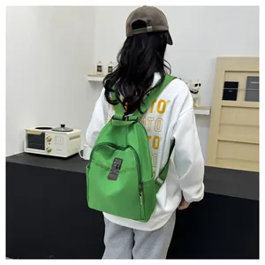 Detail of bright green waterproof nylon backpack with zipper compartments and brown leather buckle