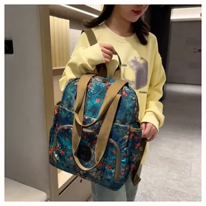 Detail of floral printed backpack with yellow straps and multi-pocket structure