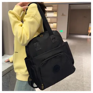 Detailed side view of a large black nylon backpack worn by a model in a casual setting