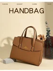 Dettaglio della borsa Kelly in pelle marrone con logo a canguro dorato e doppi manici