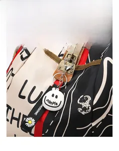 Gros plan d'un pendentif smiley blanc avec texte simple et lanière à motif marguerite