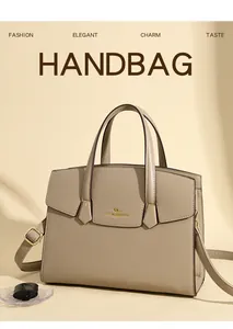 Dettaglio della borsa in pelle beige con logo a canguro dorato e scritte del marchio