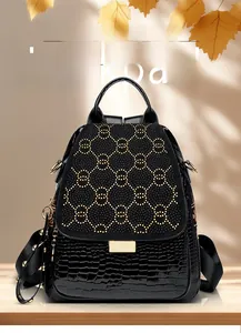 Detail of black backpack featuring gold studs in double circle pattern and crocodile texture