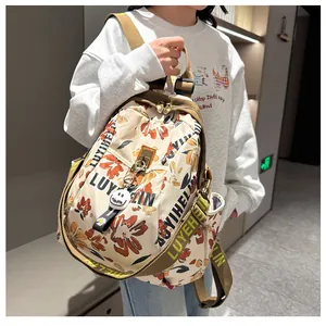 Détail du sac à dos en nylon à fleurs avec fermetures éclair et pendentif smiley