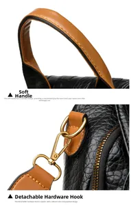 Detail of punk rivet backpack featuring brown handle and gold metal swivel hook clasp