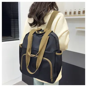 Detail of multi-pocket black nylon backpack featuring brown straps and high capacity design