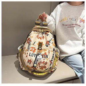 Détail d'un sac à dos floral en nylon beige avec serrure et pendentif marguerite