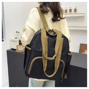 Detail of black nylon backpack with durable brown straps and functional side pockets