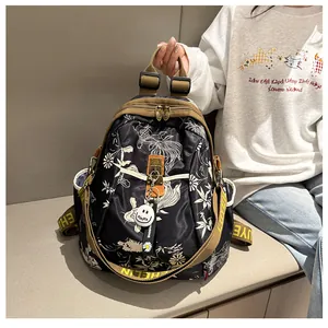 Détail du sac à dos noir avec imprimé carpe koï, sangle logo et fermeture éclair métal
