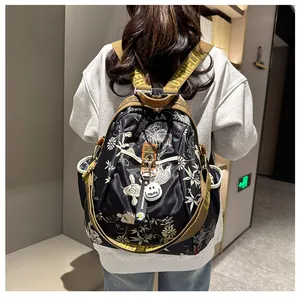 Vue détaillée du dos d'un sac à dos noir à fleurs avec des sangles tissées élégantes