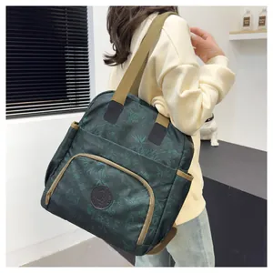 Green vintage printed backpack with floral patterns and khaki straps on a model
