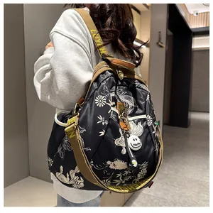 Détail d'un sac à dos graffiti avec sangle large griffée et pendentif sourire