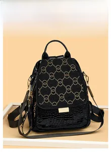 Detail of crocodile embossed leather backpack with crystal-studded circular hardware