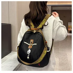 Vue arrière sac à dos en nylon noir avec pendentif marguerite et sangles à logo