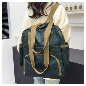 Detail of dark green floral backpack featuring thick durable straps and side pockets