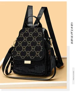 Close-up of black crocodile pattern leather backpack with gold stud motif and metallic hardware