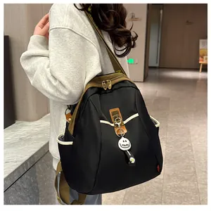 Détail du sac à dos en nylon coloré avec boucle antivol et pendentif sourire