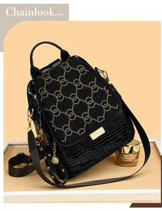 Detail of crocodile embossed leather backpack with gold studs and velvet splicing