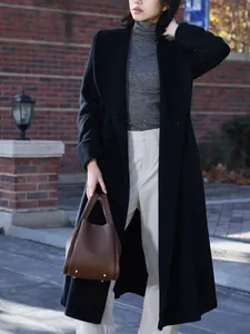 Brown lychee pattern bucket bag styled with a long black coat and grey sweater