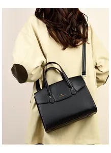 Borsa a mano classica in pelle nera abbinata a un trench beige per un look da ufficio