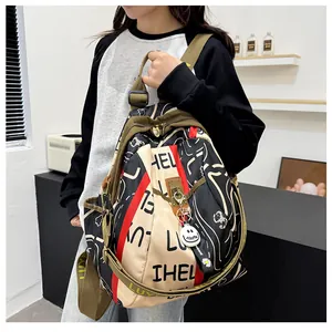 Détail de la bandoulière verte réglable et du pendentif sourire sur le sac à dos
