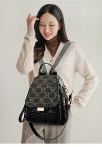Detail of black crocodile texture leather backpack with golden rivet circle patterns