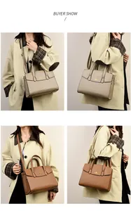 Dettaglio borsa a mano elegante in pelle martellata con logo dorato e tracolla rimovibile