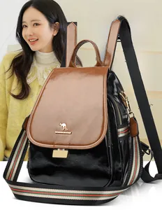 Detailed view of black leather backpack with brown flap and colorful striped fabric strap