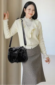 Detail of vintage black washed leather crossbody bag with silver zippers and stud accents