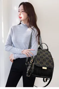 Detail view of black punk backpack with golden rivets and crocodile texture on model