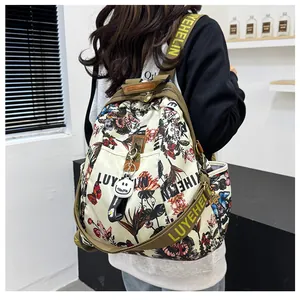 Détail du sac à dos imprimé floral avec pendentif smiley et bretelles à logo