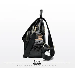 Detail of glossy black crocodile texture on backpack with premium golden hardware