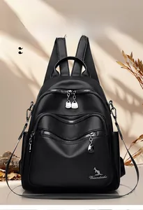 Close-up of black lychee grain leather backpack with embroidered zipper pockets and logo