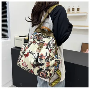 Détail d'un sac à dos blanc cassé avec imprimés papillons vintage et larges bretelles logo
