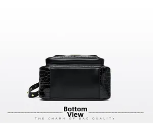 Detail view of the black backpack bottom featuring crocodile pattern and golden metal rivets