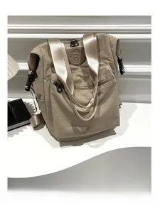 Detail view of khaki nylon backpack featuring RMENGXIAOMI logo and adjustable straps