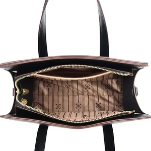 Vista dall'alto della borsa tote in pelle nera con interno con logo e dettagli dorati