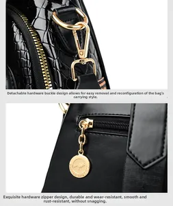 Close-up of golden metal zipper and snap hooks on black crocodile pattern bag