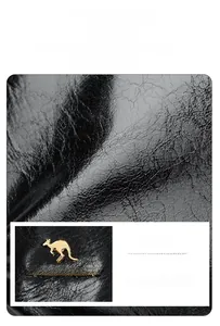 Detail of high-quality cowhide texture and gold kangaroo metal logo on black leather bag