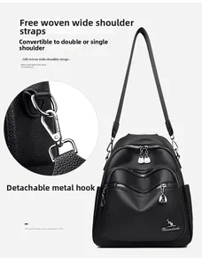 Detail of silver-tone hardware hook and woven shoulder strap on black leather backpack