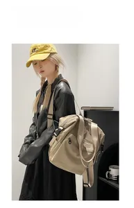 Detail of multi-pocket beige nylon backpack with adjustable wide shoulder straps