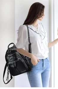 Detail shot of black litchi pattern leather backpack with zipper and logo