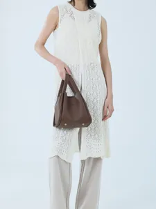 Detail of lychee pattern leather handbag with metallic bottom studs and brand logo