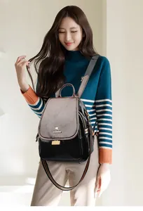 Detail of grey and black patchwork backpack with kangaroo logo and striped strap