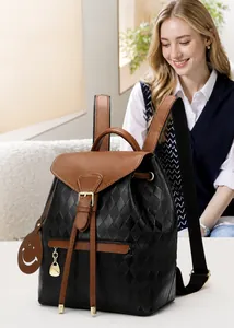 Détail de la couture matelassée et du rabat en cuir marron d'un sac à dos pour femme